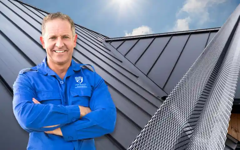 Leaf Guard Australia tradesman in front of a metal roof fitted with mesh gutter guard